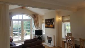 a living room with a couch and a tv at Beechfield Cottages in Meopham