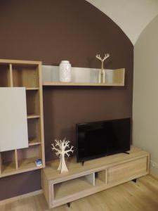 a living room with a flat screen tv and shelves at Un temps pour nous in Durbuy