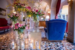 a table with vases filled with flowers and candles at Hotel Villa Flori in Como