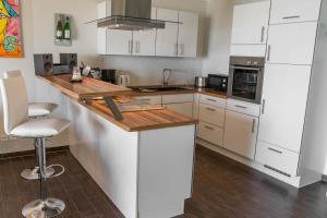 a kitchen with white cabinets and a wooden counter top at Residenz am Yachthafen in Cuxhaven