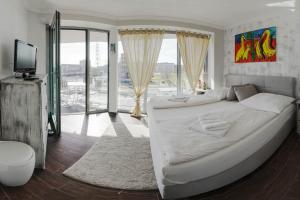 a large white bed in a room with windows at Residenz am Yachthafen in Cuxhaven