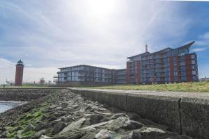 un edificio y un faro frente a un edificio en Residenz am Yachthafen, en Cuxhaven