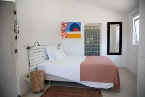 a white bedroom with a white bed and a window at Casal do Frade in Sesimbra