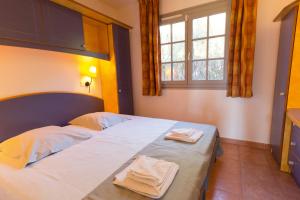 a bedroom with a bed with two towels on it at SOWELL RESIDENCES Chênes Verts in Saint-Raphaël