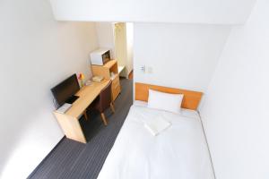 mały pokój z łóżkiem i telewizorem w obiekcie FLEXSTAY INN Tokiwadai w Tokio