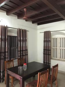 a dining room with a black table and chairs at Palm Rivera Kochi in Cochin