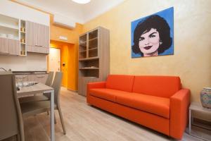 ローマにあるJackie's Apartmentsのリビングルーム(オレンジ色のソファ、絵画付)