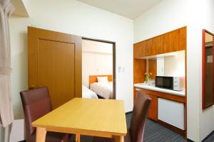 a small room with a table and a bed at FLEXSTAY INN Tokiwadai in Tokyo