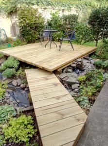 a wooden platform with a table and a chair on it at Paeroa bed and breakfast in Paeroa