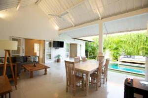 a dining room and living room with a table and chairs at Villa Niluh in Canggu