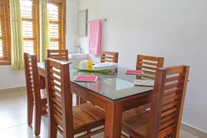a dining room with a table with chairs and a sink at Coorg Rahul Villa- 3 Deluxe Bedrooms in Madikeri