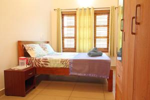 a small bedroom with a bed and a window at Coorg Rahul Villa- 3 Deluxe Bedrooms in Madikeri