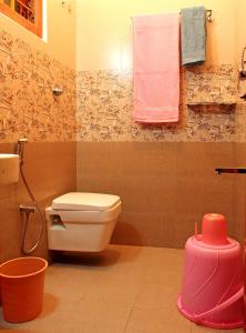 a bathroom with a toilet and a sink and towels at Coorg Rahul Villa- 3 Deluxe Bedrooms in Madikeri