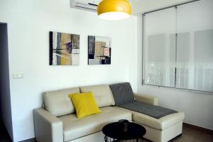 a living room with a couch and a yellow pillow at El Jardin BeNerja in Nerja