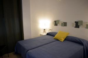 a bedroom with a bed with a yellow pillow on it at El Jardin BeNerja in Nerja