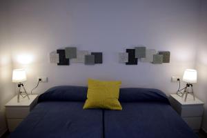 a bedroom with a bed with a yellow pillow on it at El Jardin BeNerja in Nerja