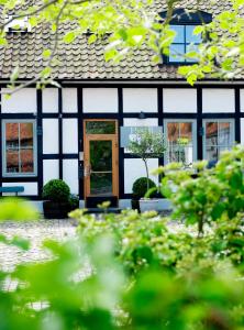 uma casa branca e preta com uma porta em Hotel Kockska Gården em Simrishamn