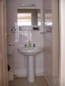 bagno con lavandino e specchio di The Florida Guest House a Paignton