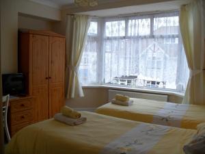 een slaapkamer met 2 bedden en een raam bij The Florida Guest House in Paignton