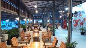 a row of wooden chairs and tables in a building at Phurang Hill Resort in Kanchanaburi City
