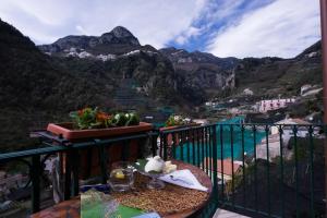 uma varanda com uma mesa e vista para as montanhas em La Valle Delle Ferriere em Amalfi