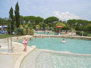 una niñita parada en el agua en una piscina en Italia Family Camping Village Viareggio, en Torre del Lago Puccini
