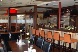 a restaurant with a table and chairs and a bar at Hotel Restaurant Zum Hollengrund in Heeslingen