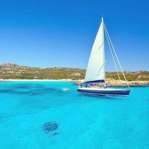 una barca a vela in acqua in un grande corpo d'acqua di Appartamenti Milù a La Maddalena