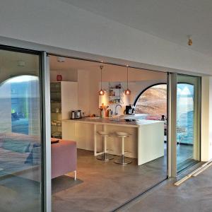 une cuisine et une salle à manger avec des portes coulissantes en verre dans l'établissement Ocean Loft, à Maspalomas