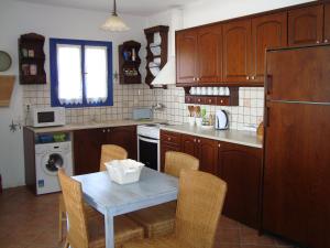 Agios DimitriosにあるWide sea Maisonetteのキッチン(テーブル、椅子、冷蔵庫付)