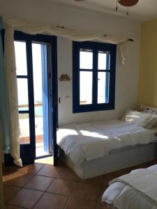 a bedroom with two beds and an open door at Wide sea Maisonette in Agios Dimitrios