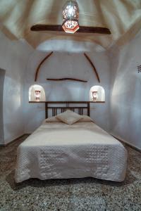 a bedroom with a bed in a room with a ceiling at Cueva El Murallon Benamaurel in Benamaurel