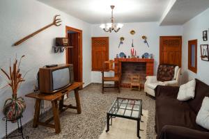 a living room with a tv and a fireplace at Cueva El Murallon Benamaurel in Benamaurel