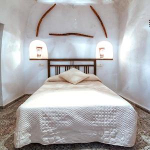 a bedroom with a white bed in a room at Cueva El Murallon Benamaurel in Benamaurel