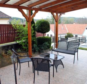 a group of chairs and a table on a patio at Erdőszéli Házikó Vendégház in Bükkszék