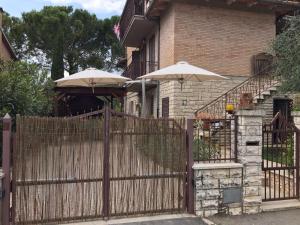 a fence with two umbrellas in front of a house at C'era una volta in Asciano