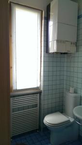a bathroom with a toilet and a window and a sink at Villetta Cinquale Versilia in Cinquale