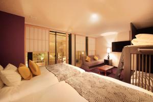 a bedroom with a large bed and a living room at Centurion Hotel Ueno in Tokyo