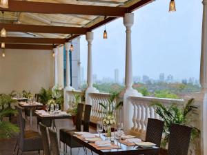 un ristorante con tavoli e sedie e un balcone di Majestic Court Sarovar Portico a Navi Mumbai