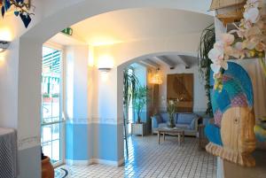 un couloir avec un salon bleu et blanc dans l'établissement Hotel La Goletta, à Lignano Sabbiadoro