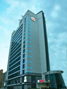 Un alto edificio blu con un orologio sopra. di Ramee Rose Hotel a Dubai