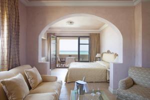 a hotel room with a large bed and a large window at Aquila Rithymna Beach in Adelianos Kampos