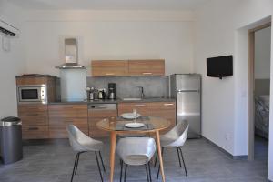 a kitchen with a table and chairs in a kitchen at Villa Valflor chambres d'hôtes et appartements in Marseille