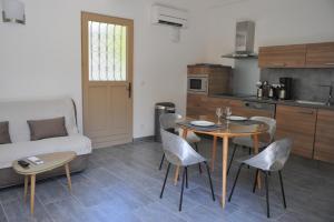 a kitchen and a living room with a table and chairs at Villa Valflor chambres d'hôtes et appartements in Marseille