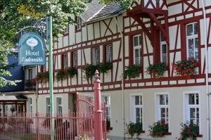 a large white building with a sign in front of it at Hotel Garni Lindenmühle in Bad Neuenahr-Ahrweiler