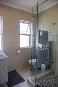 a bathroom with a toilet and a glass shower at The Waterfront Cottage F12 in Swakopmund