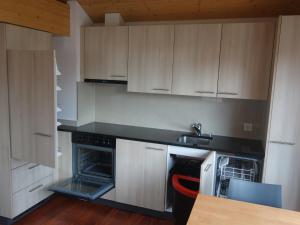 a kitchen with white cabinets and a sink and a stove at Royal Swiss Apartments in Ringgenberg
