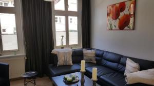 ein Wohnzimmer mit einem blauen Sofa und 2 Fenstern in der Unterkunft Altstadtloft Lüneburg in Lüneburg
