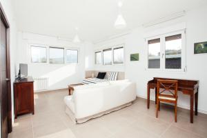 a white living room with a white couch and a desk at Apartamentos Florida 30 in Hernani
