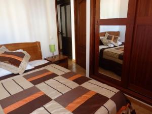 a bedroom with two beds and a mirror at Casa Riqueta Silva in Bordeira